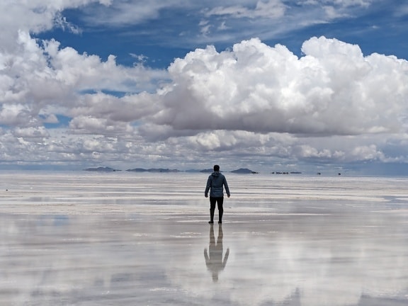Person standing on a salt flat surface in Salar de Uyuni natural park in Bolivia