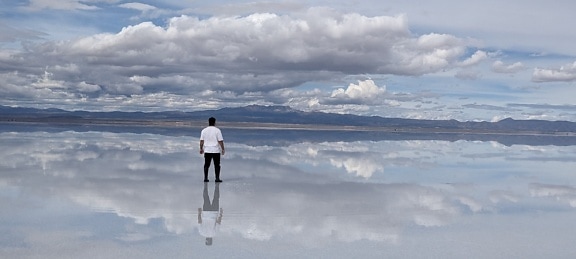 Optical illusion of a man standing on a surface of water