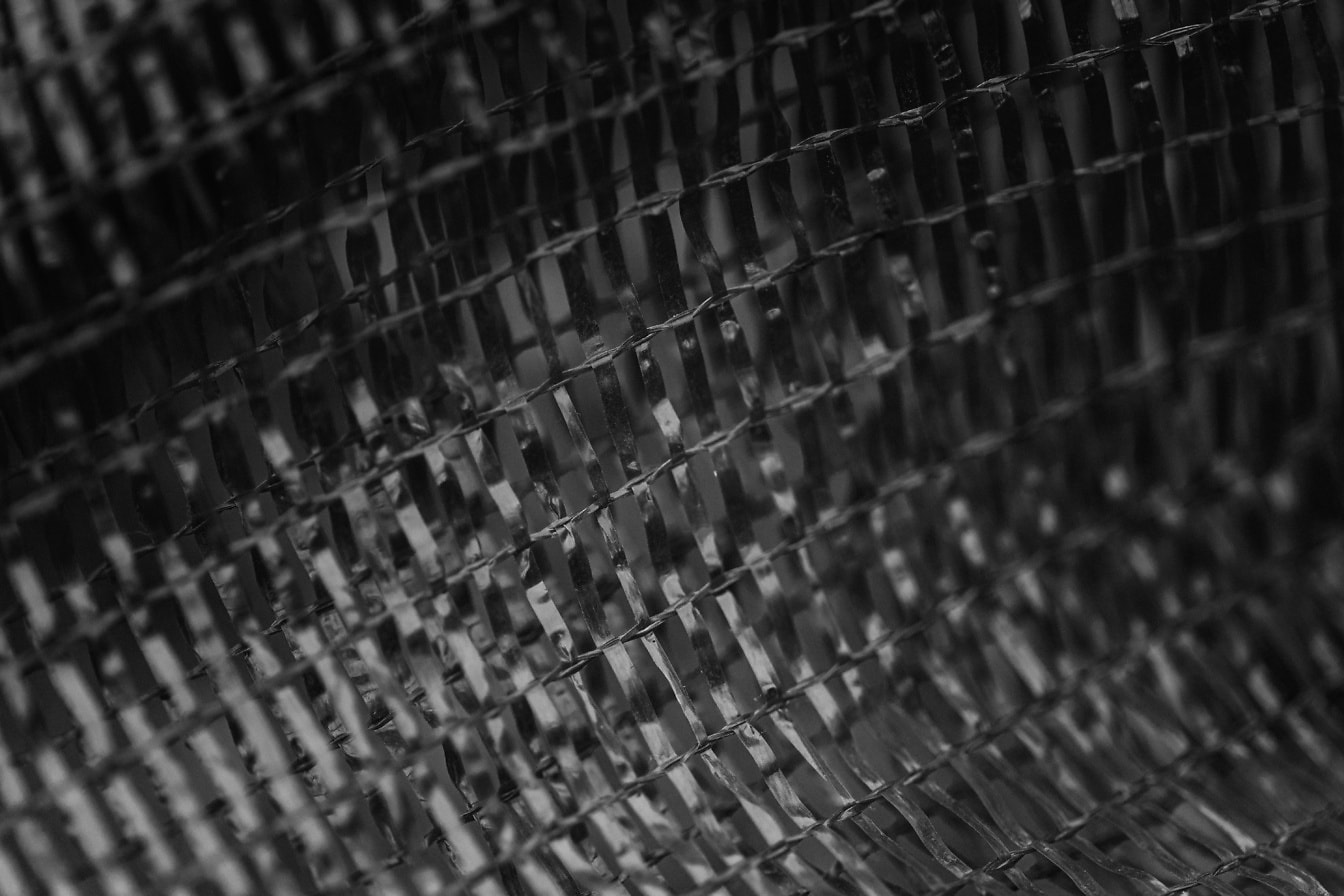 Textura plastového síťovaného sáčku, černobílá fotografie