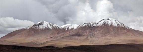 Lumisia vuorenhuippuja Atacaman autiomaassa Boliviassa Etelä-Amerikassa