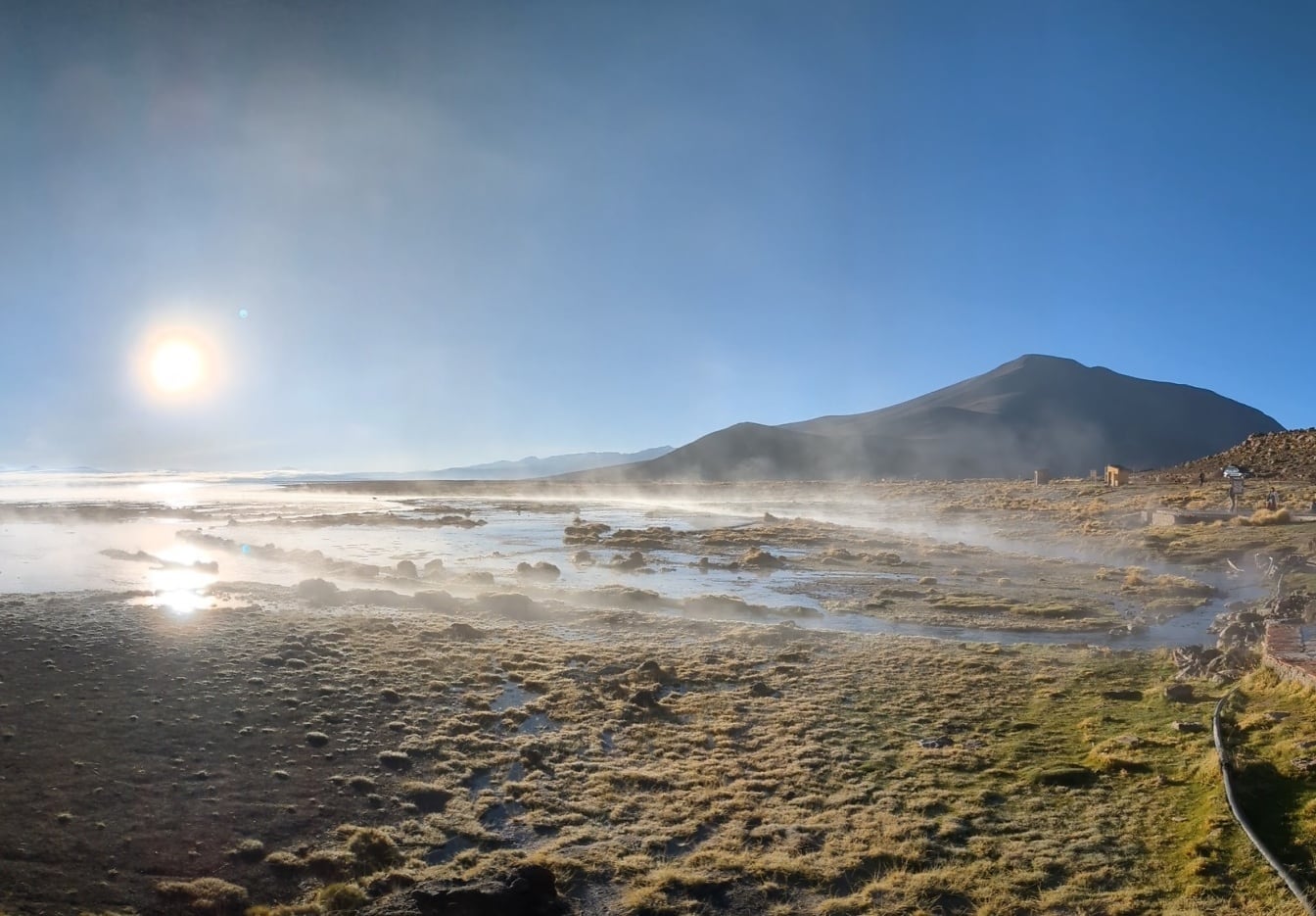 Napfelkelte a Laguna Polques-nál az Uyuni sós tónál, a bolíviai fennsíkon, geotermikus meleg forrásokkal