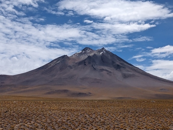 Vulcano Miñiques in Cile, montagna con un campo piatto e cielo blu