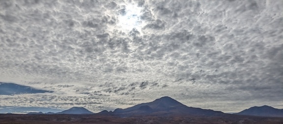 Mountains in desert with clouds in the sky