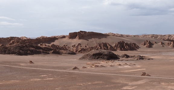 칠레의 달의 계곡에 언덕이 있는 사막의 먼지 투성이의 도로