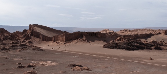 칠레의 달의 계곡에 먼지 투성이의 도로와 언덕이 있는 사막 풍경