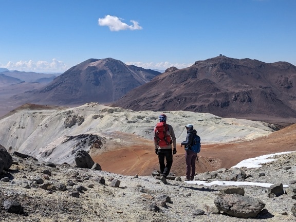 Two mountain climbers walking on a Cerro Toco mountain peak in Chile