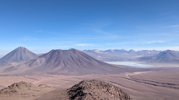 Cordillera desértica con un lago salado en la meseta en la distancia