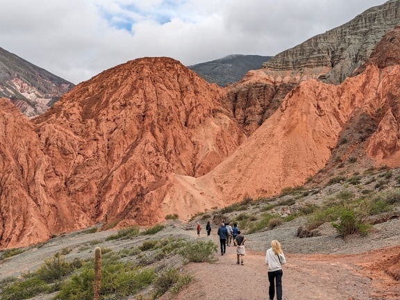 Hikers walking on mountain in northern Argentina known as rainbow mountain