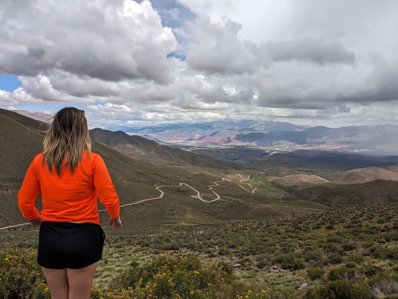 아르헨티나의 Humahuca 계곡을 바라 보는 산에 서있는 여자