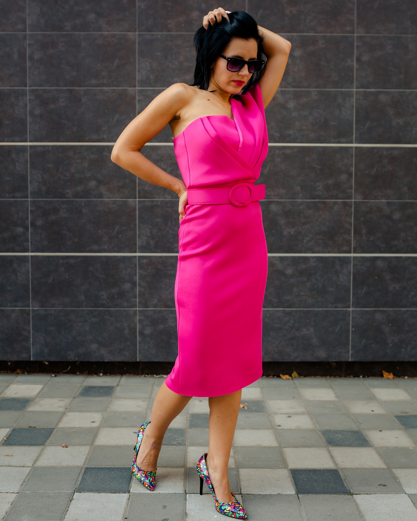 Underbar ung kvinna fotomodell som poserar i en livlig rosa klänning