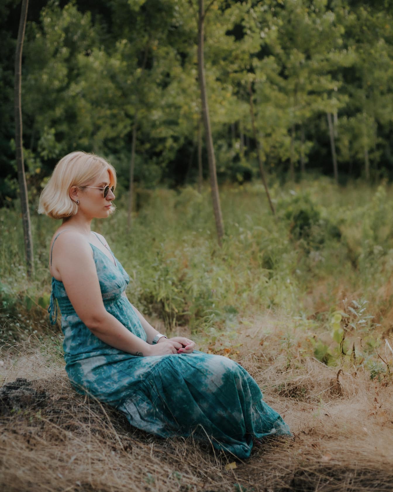 Жена седи в гората и медитира