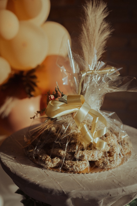 Handmade cookies wrapped in cellophane with shining ribbon as gift