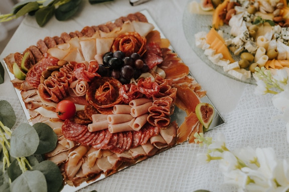 Appetizer tray with homemade pork sausages and ham on the banquet table