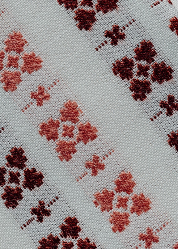Hand-embroidery with retro ornaments on white cotton fabric
