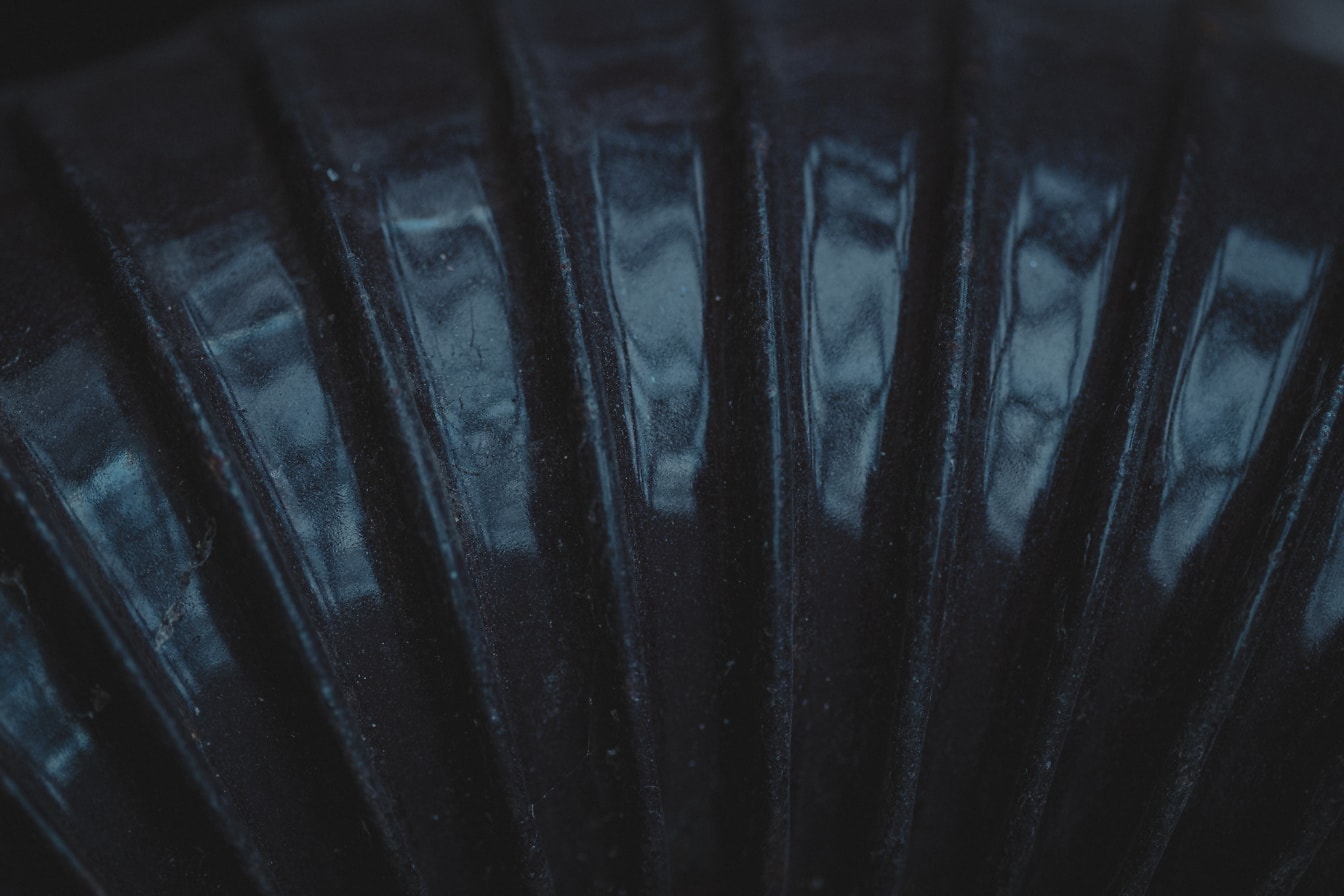 Текстура глянцевого черного цвета на деформированной металлической трубке