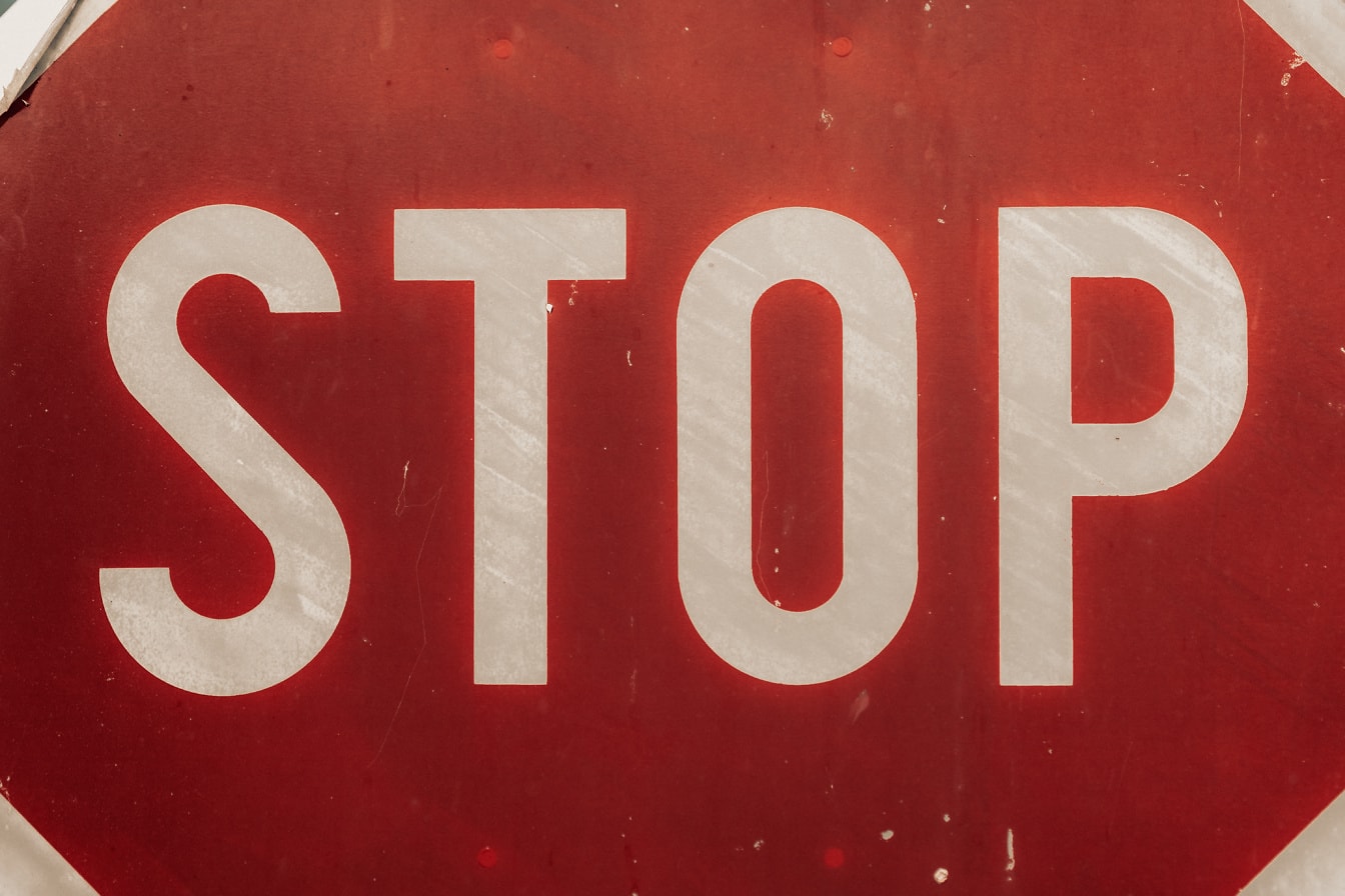 Znak stop, prometni znak s bijelim slovima na crvenoj površini