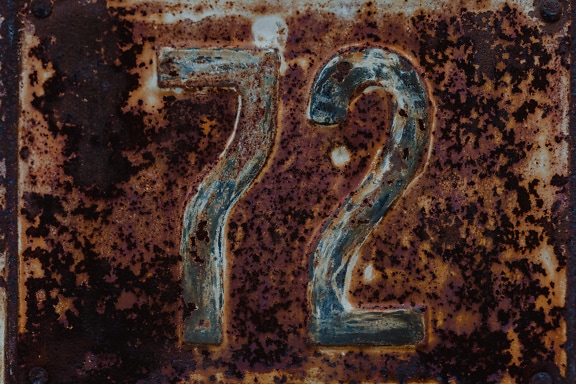 Number 72 on a rusty metal surface