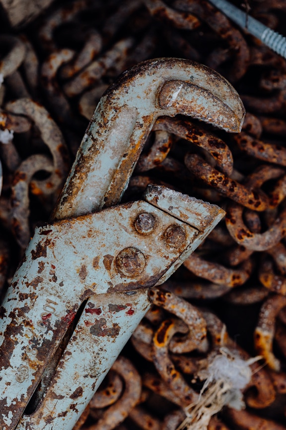 Rusty wrench on old iron chains