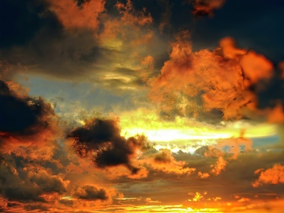 Amazing sunset with bright sunrays through dark storm clouds