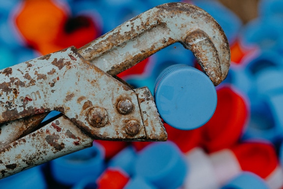 Old rusty wrench holding a bottle cap
