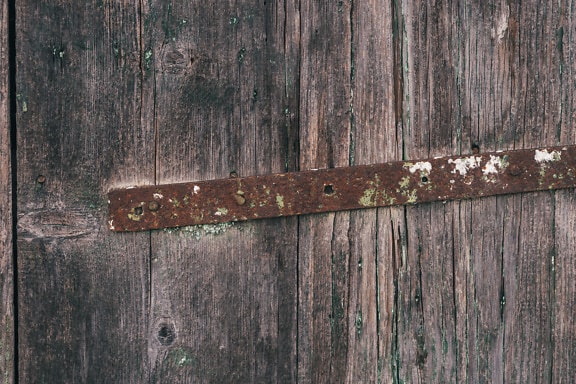 古い木製のドアの錆びた金属補強