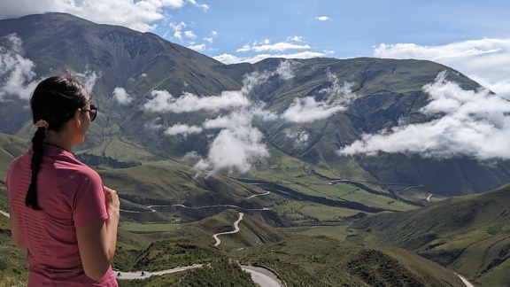 アルゼンチン北西部の道路で渓谷の息を呑むような景色を楽しむ女性