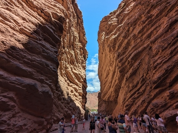 Tourists walking through a narrow canyon, a touristic attraction in Argentina