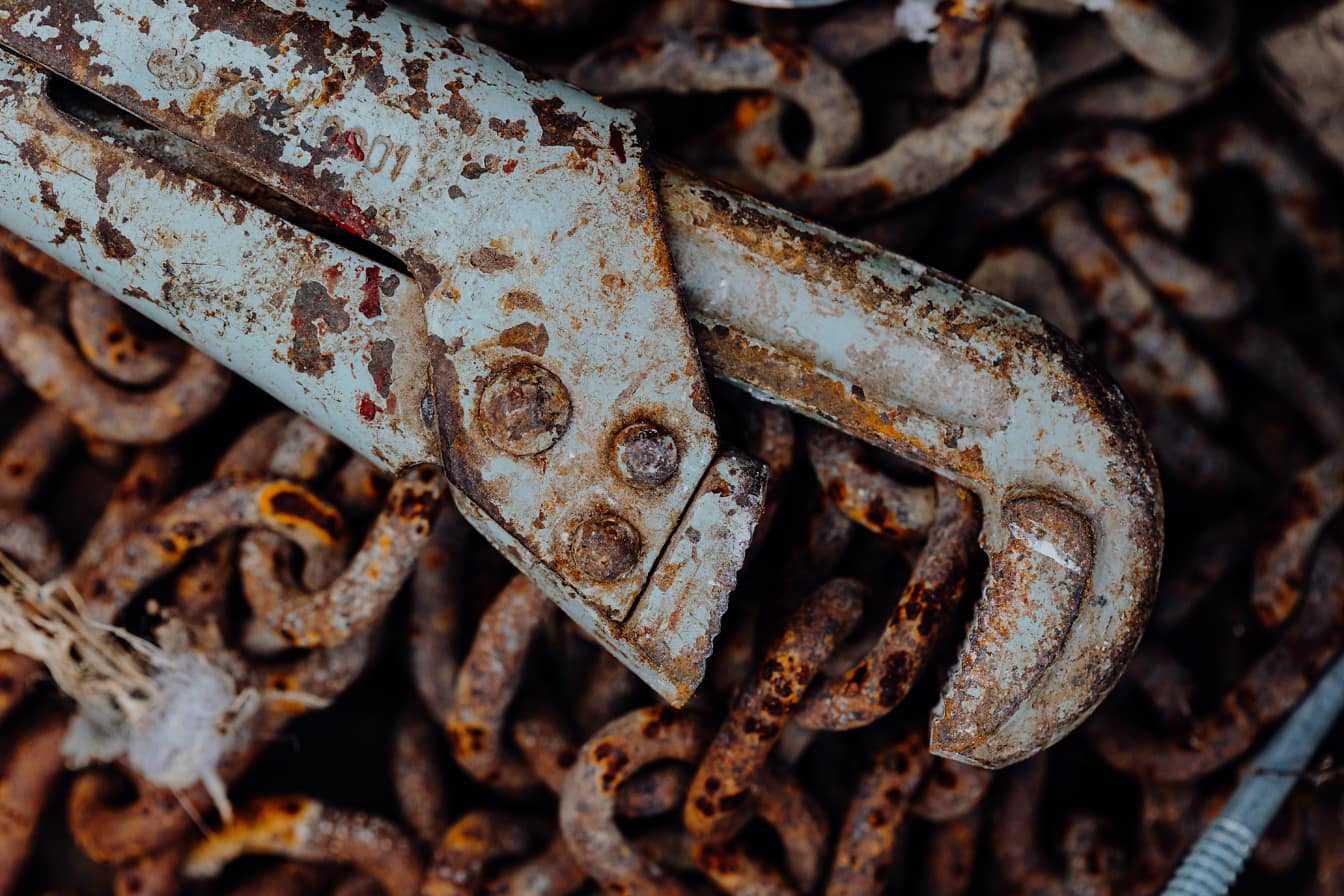 Una vieja llave mecánica en una cadena oxidada