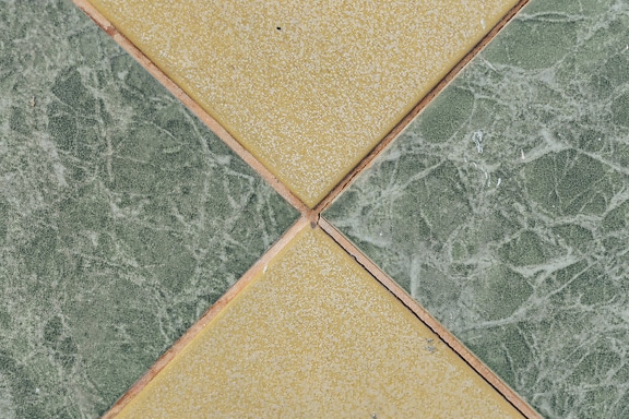 Texture of two types of floor tiles, one yellowish brown and another greenish