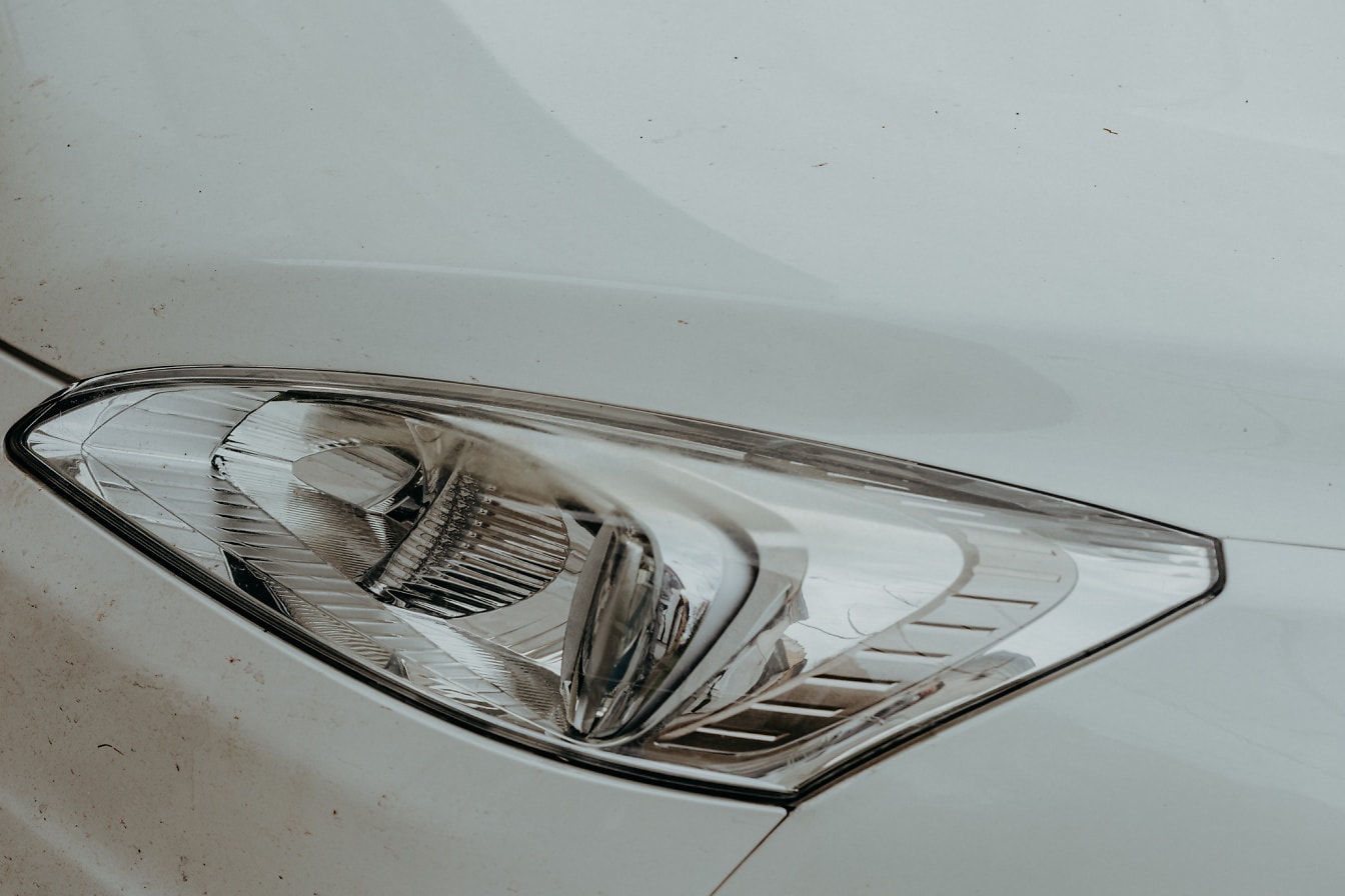 Nærbilde av frontlys av hvit bil