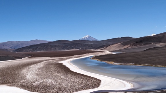 Landscape of Laguna Negro in a desert plateau and with the Pissic volcano in the background