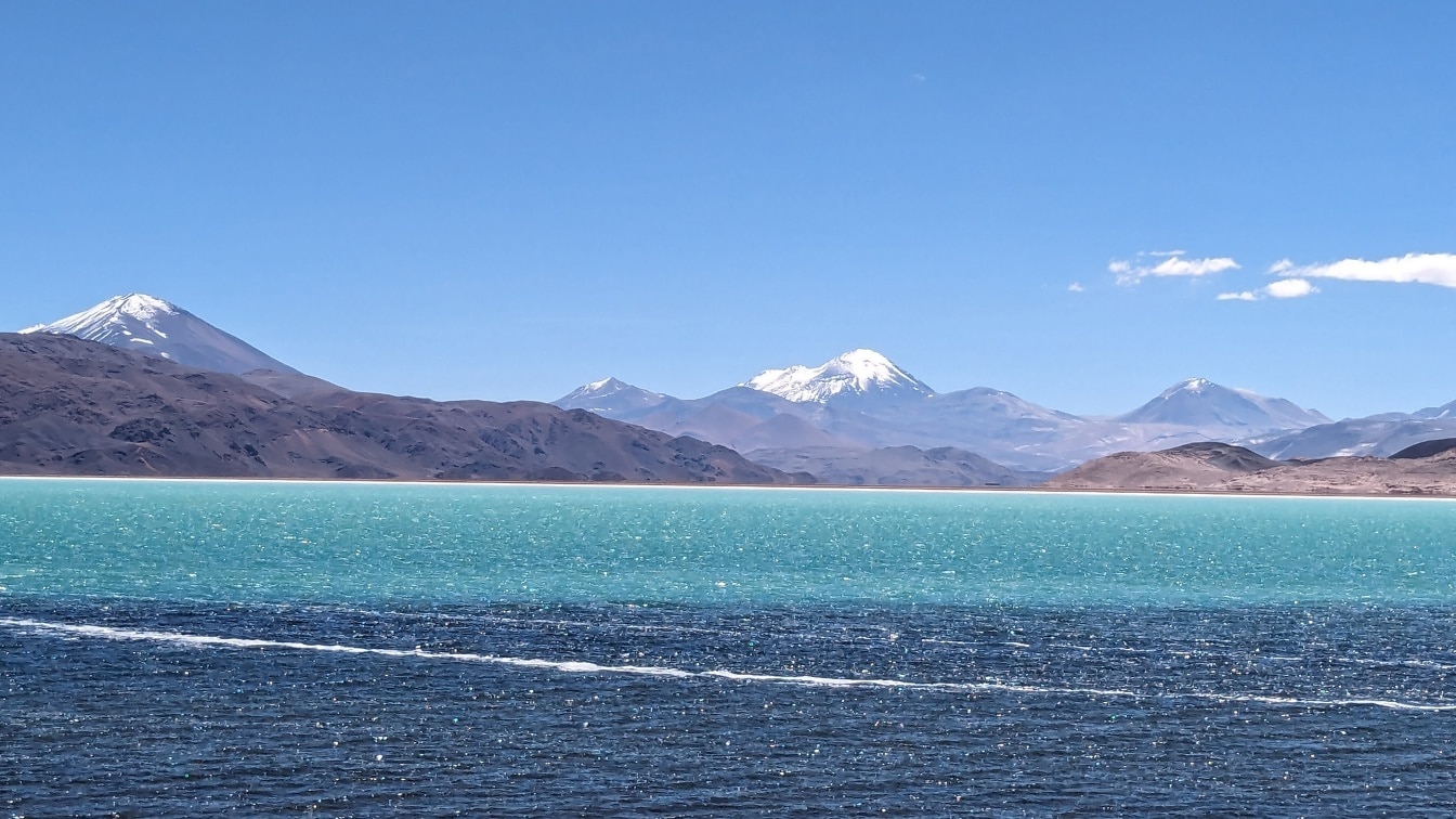 Majestátní jezerní krajina na vysokohorské plošině v Jižní Americe se zasněženými vrcholky hor v pozadí