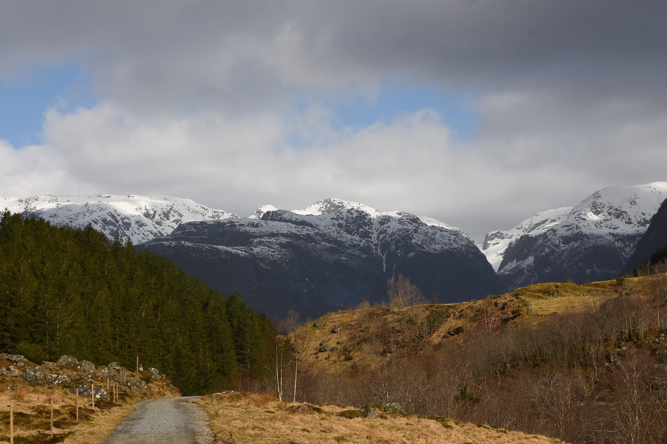 Jalan di lembah puncak gunung bersalju di cagar alam di Norwegia