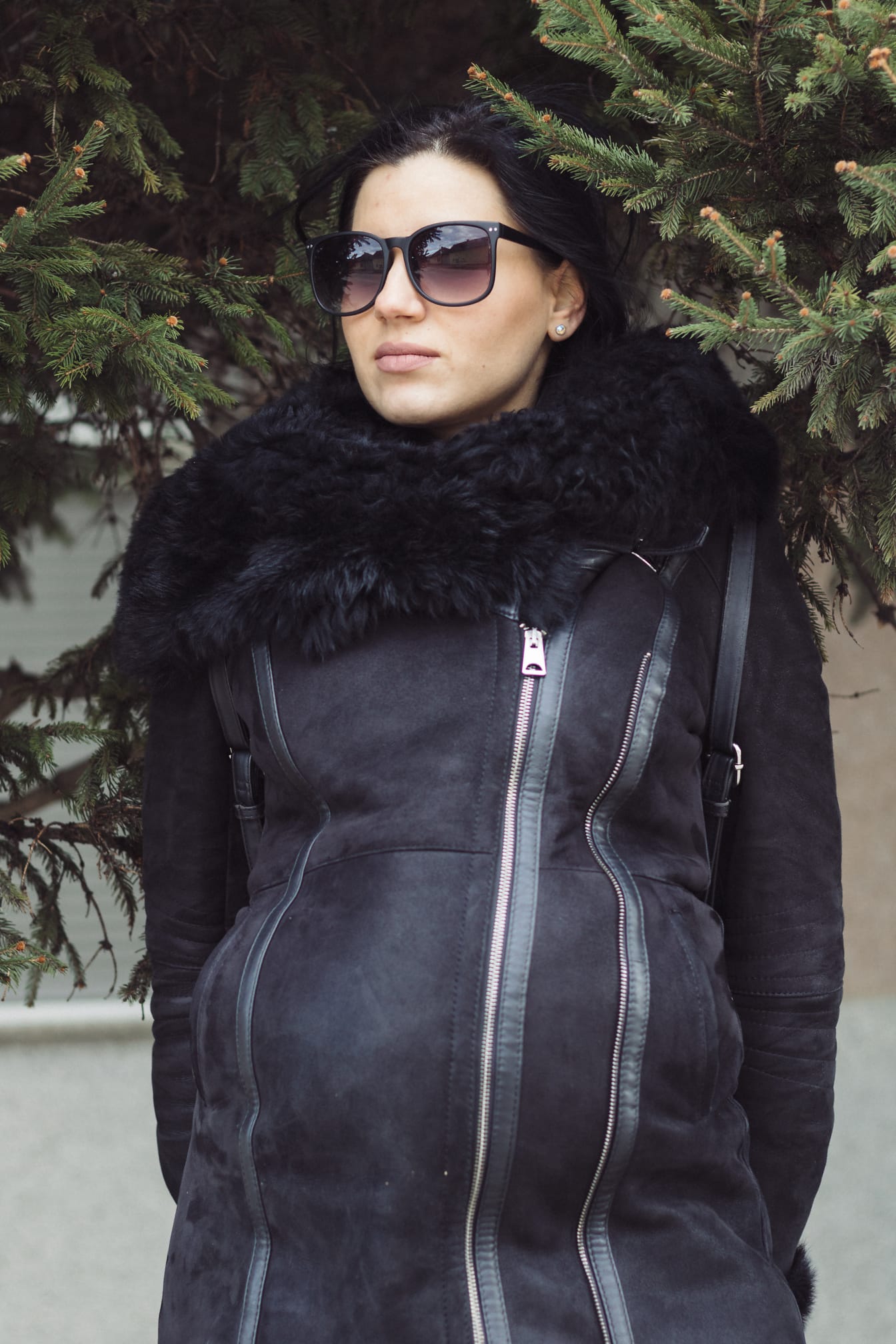 Dobře vypadající mladá žena se slunečními brýlemi a kožešinovým kožešinovým kabátem