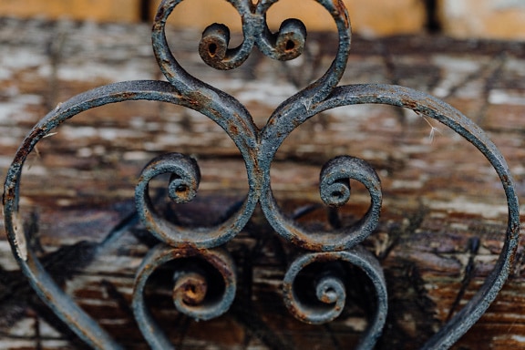 A heart shaped ornament on cast iron fence
