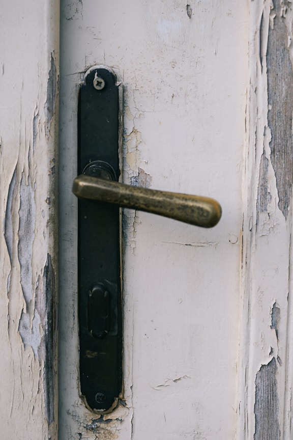 Rustic metal door handle on a white door