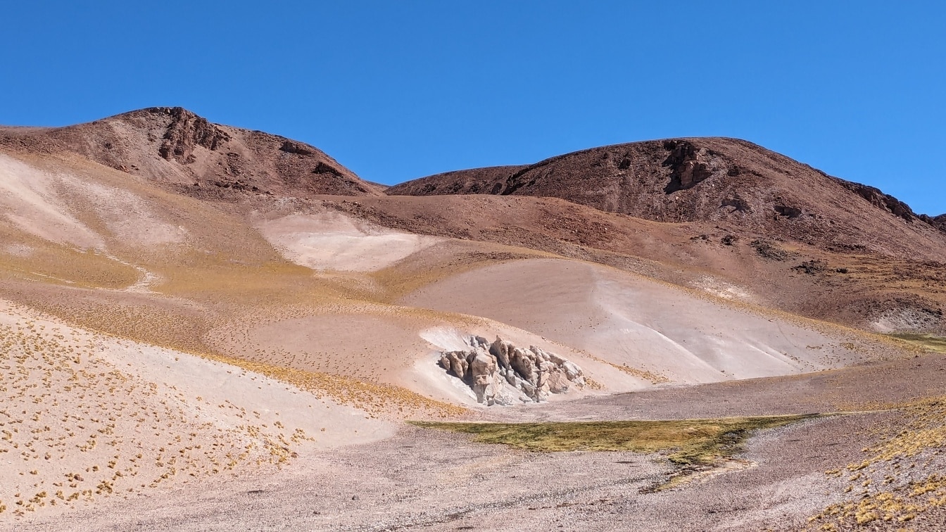 Những ngọn đồi lớn màu nâu nhạt với bầu trời xanh ở Salar de Antofalla trên sa mạc Atacama;