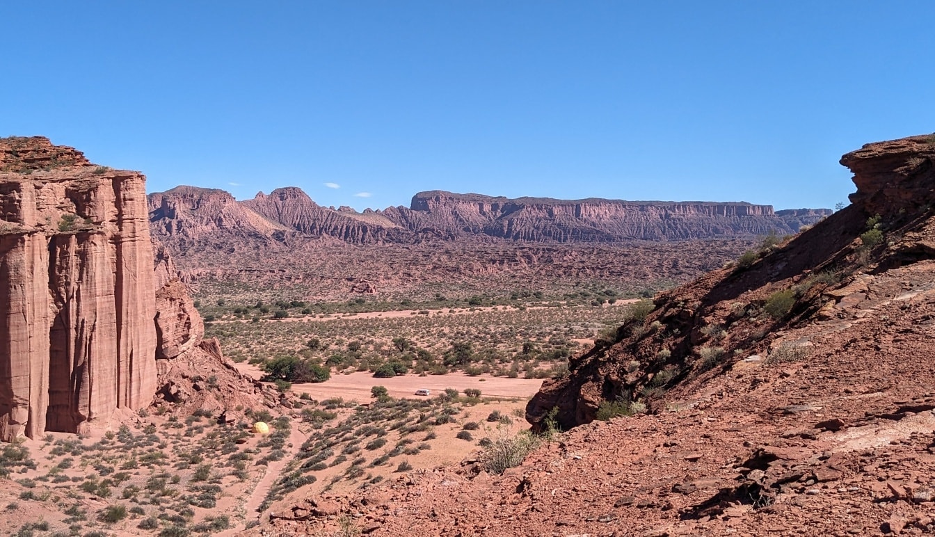 Krajina púšte s horami sedimentov a modrou oblohou v národnom parku Talampaya v Argentíne