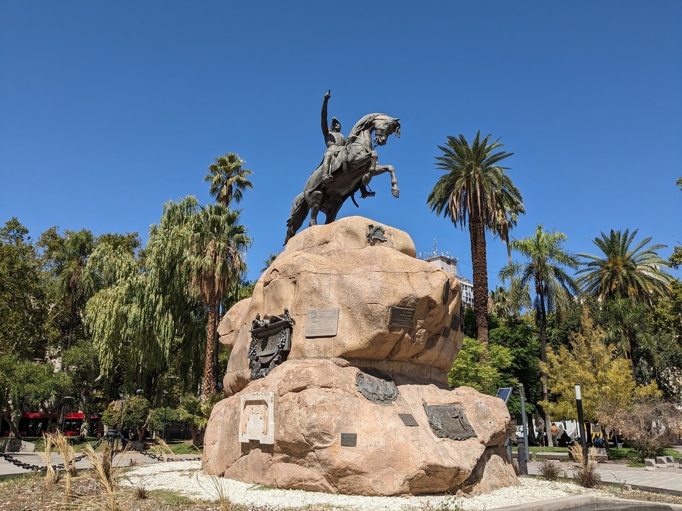 A statue of General José de San Martín riding a horse on a large rock in Plaza San Martin in Mendoza town in Argentina