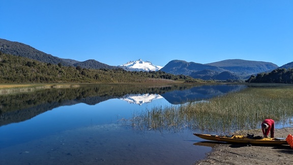아르헨티나 나우엘 나피 국립공원에 있는 리오네그로(Rio Negro) 지방의 파타고니아(Patagonia)에 있는 라고 헤스(Lago Hess) 호수 기슭에서 카누를 타고 있는 사람