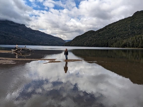 Woman standing in the water of the Lago Falkner lake located in the Nahuel Napi national park in Argentina