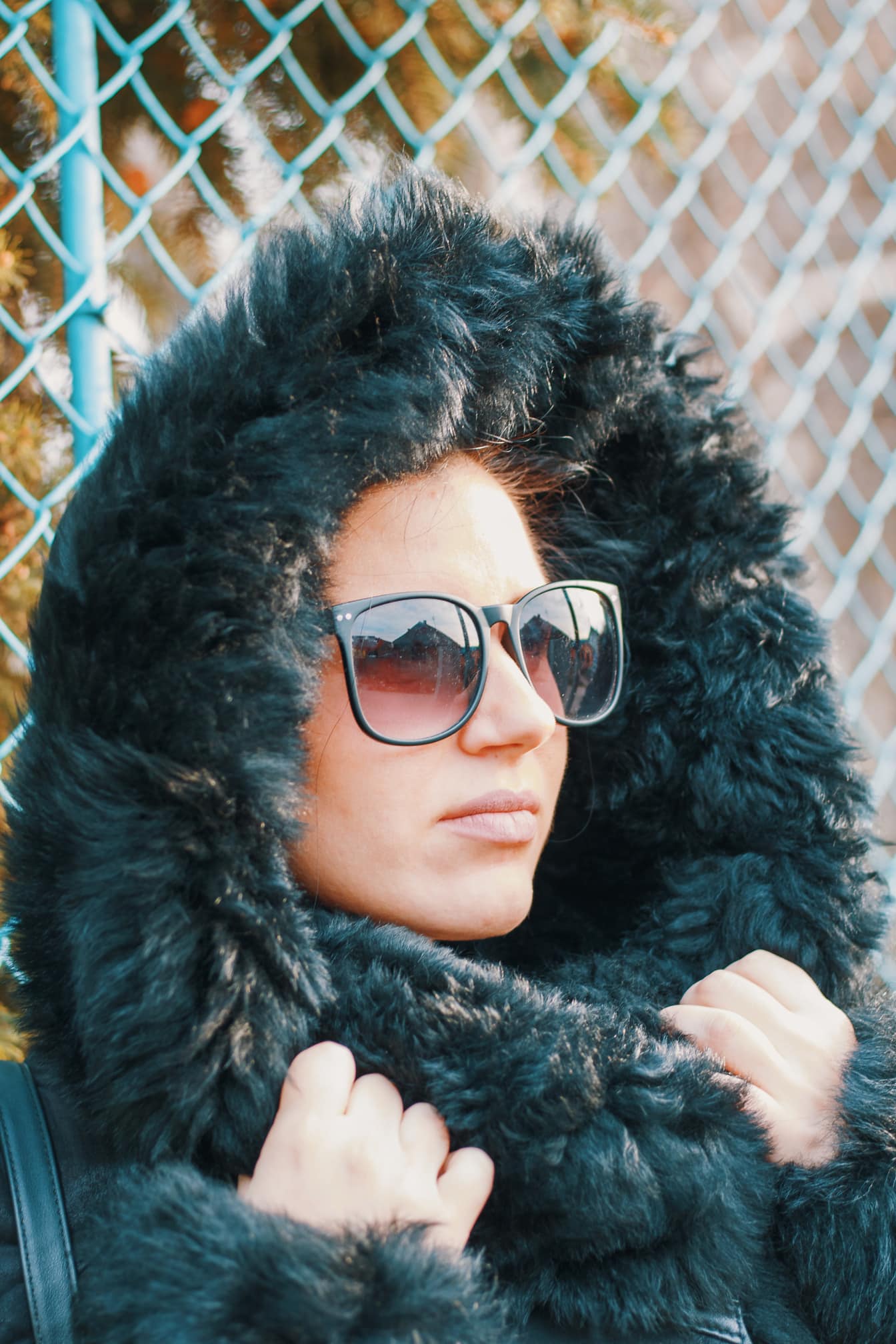 Ritratto di una donna che indossa occhiali da sole e un cappuccio di pelliccia