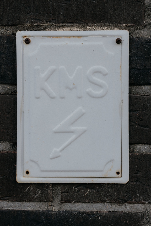 Rectangular electric box on brick wall with a thunderbolt sign on it