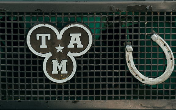 Superficie metallica con ferro di cavallo e logo di un ex costruttore di autocarri dell’ex Jugoslavia (TAM)