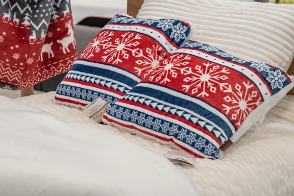 Red-blue pillows with New Year’s motifs on a bed