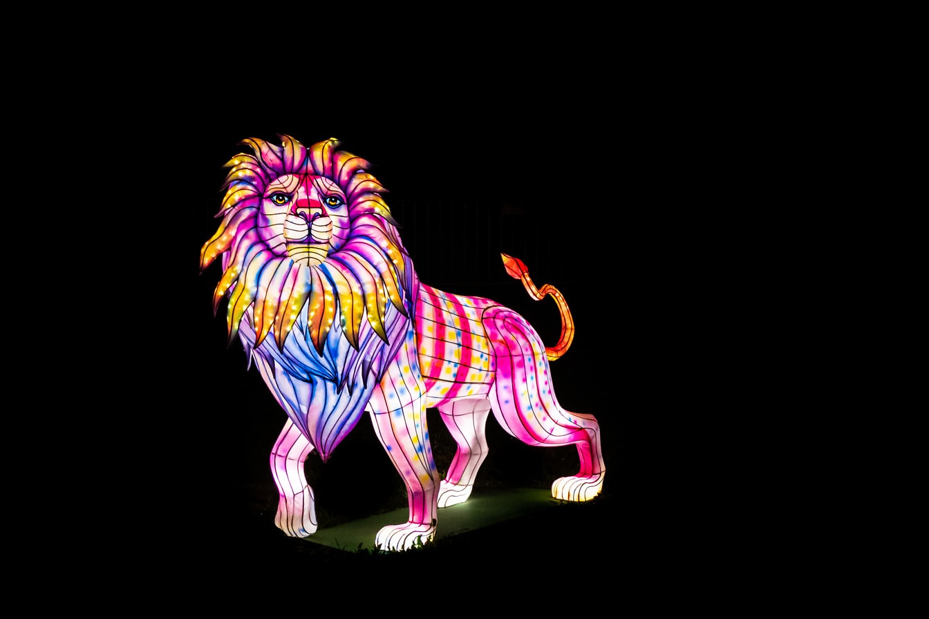 En farverig oplyst statue af en løve om natten