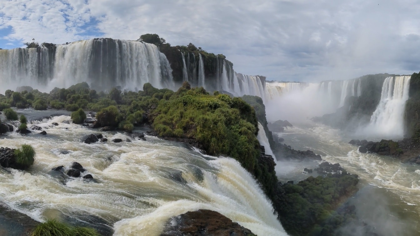 Een mistig landschap van de Iguazu-waterval met groene planten en rotsen op kliffen