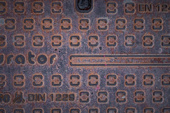 Texture of a rusty cast iron surface of manhole cover