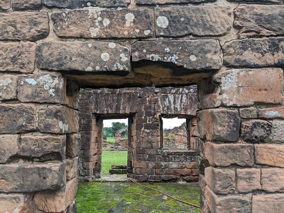 A medieval ruin with a doorway at brick wall at an archaeological site in Paraguay