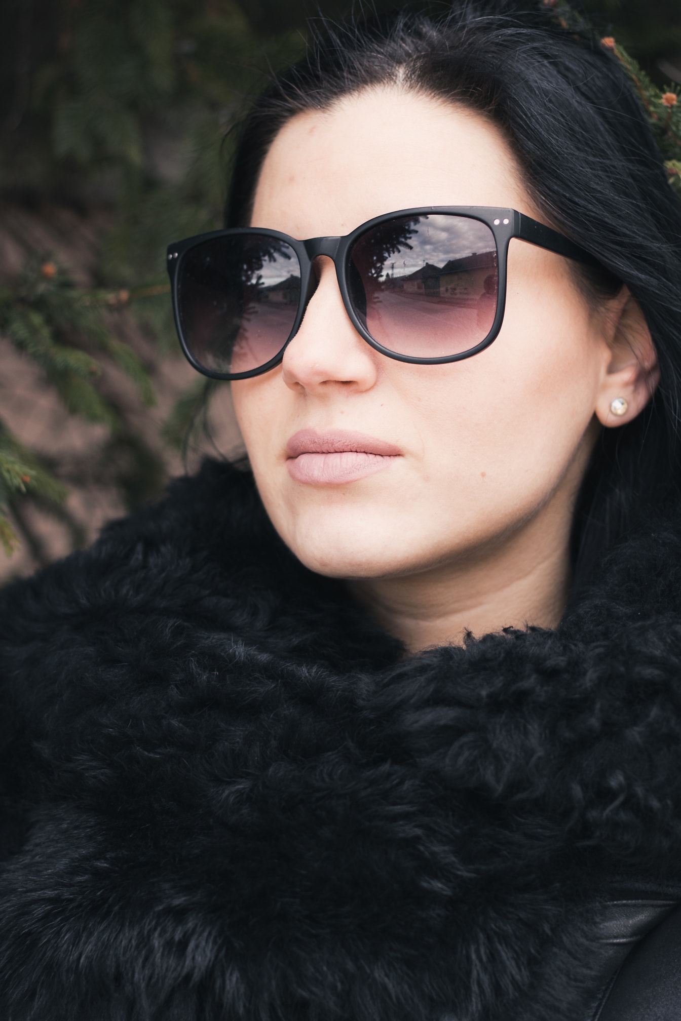 Portrét atraktivní ženy se slunečními brýlemi a kožichem